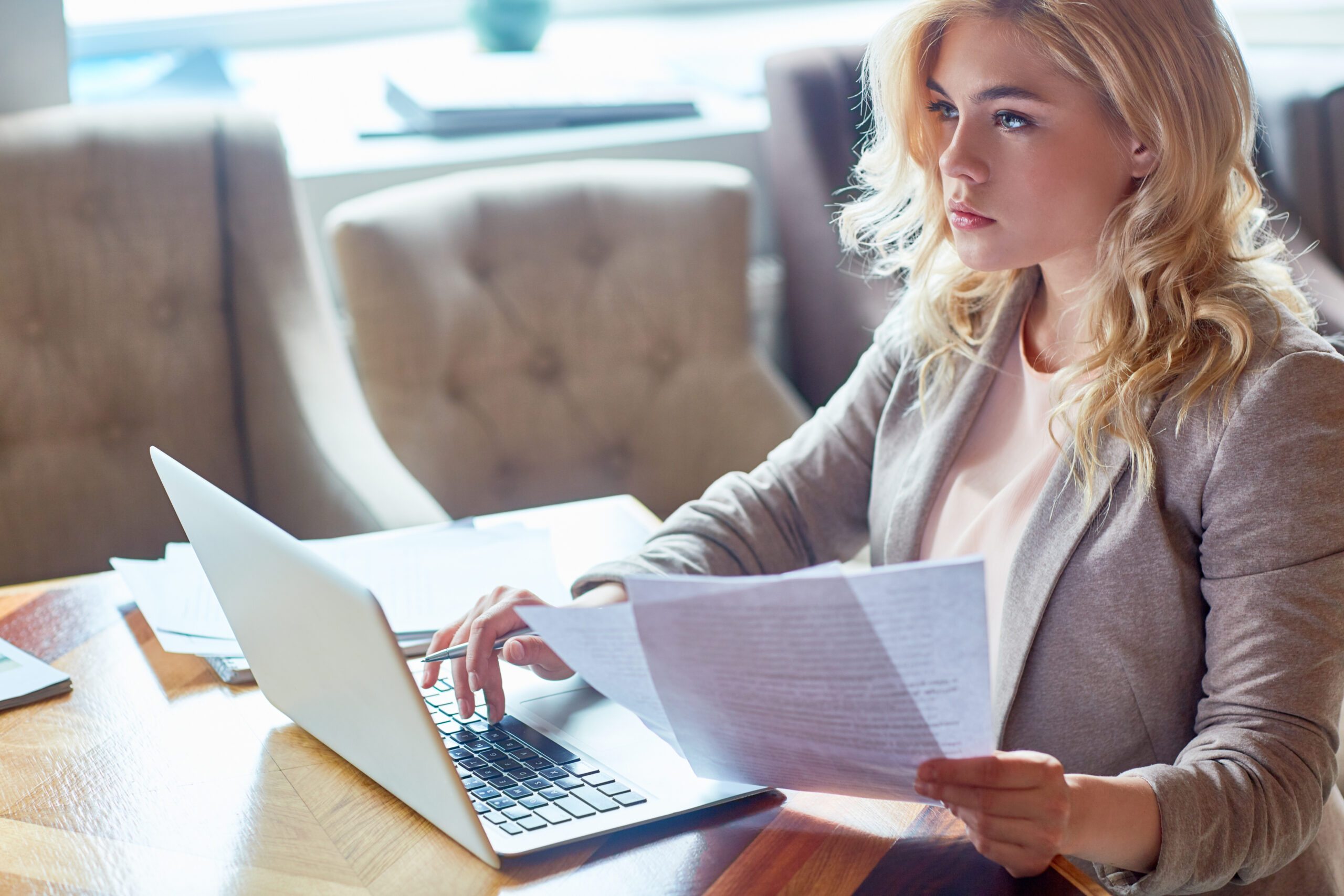 Small business owner reconciling bank statements on a laptop — reviewing monthly transactions and matching records using a free online tool
